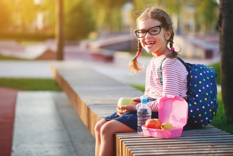Enfant d'écolière mangeant des pommes de déjeuner à l'école photos libres de droits