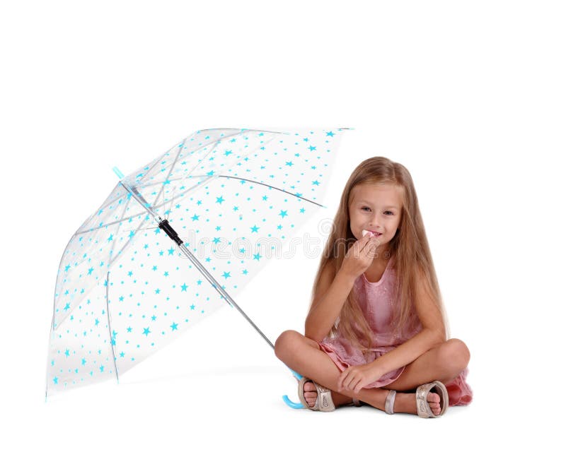 Enfant d'élève du cours préparatoire mangeant des bonbons Fille avec du charme s'asseyant avec le parapluie d'isolement sur un fo images stock Enfant d'élève du cours préparatoire mangeant des bonbons Fille avec du charme s'asseyant avec le parapluie d'isolement sur un fo images stock