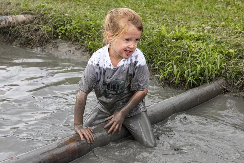 Enfant dans le fossé dans la course de boue image libre de droits Enfant dans le fossé dans la course de boue image libre de droits