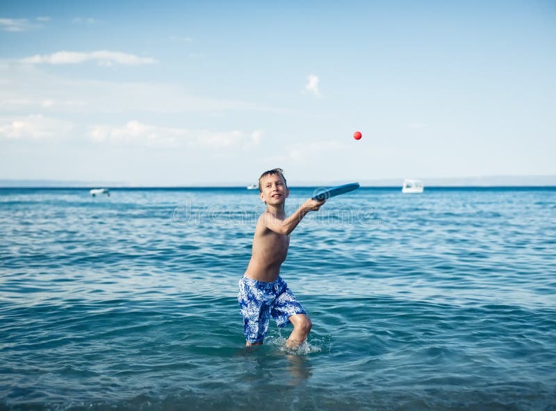 Enfant Gai Mignon Dans Le Swimware Jouant En Mer Avec Le Jouet Photo