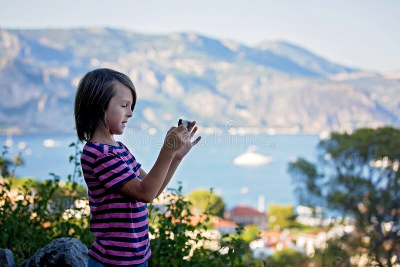 Enfant de la préadolescence prenant des pictires avec le mobile de la vue sur la Côte d'Azur photos stock