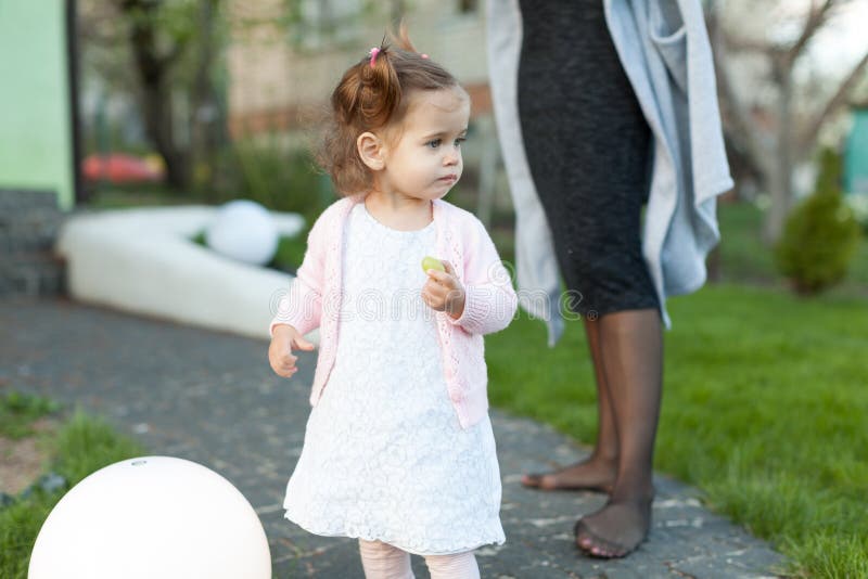 Enfant de petite fille jouant sur la pelouse dans l'arrière-cour avec une grande lampe électrique photo libre de droits Enfant de petite fille jouant sur la pelouse dans l'arrière-cour avec une grande lampe électrique photo libre de droits