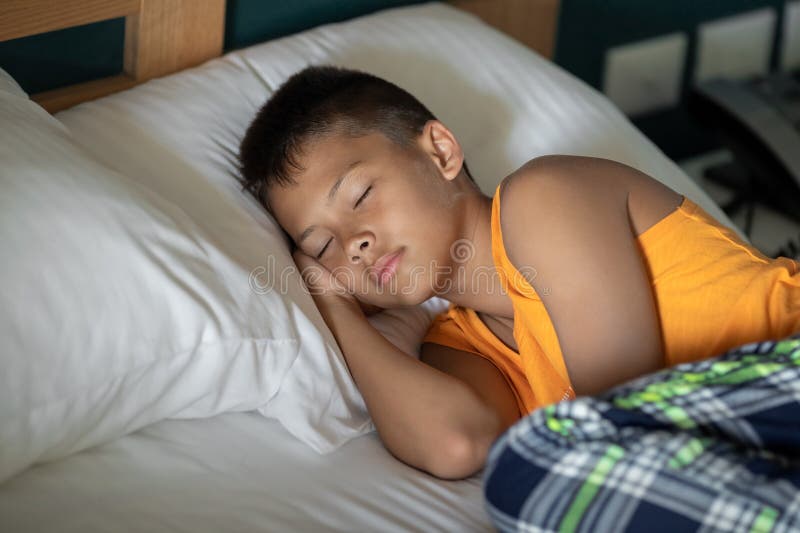 Enfant de prédilection dormir dans un lit confortable dans l'hôtel de complexe prendre une sieste garçon caucasien image libre de droits