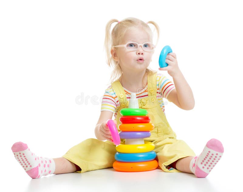 Enfant drôle dans les eyeglases jouant la pyramide colorée photo libre de droits Enfant drôle dans les eyeglases jouant la pyramide colorée photo libre de droits