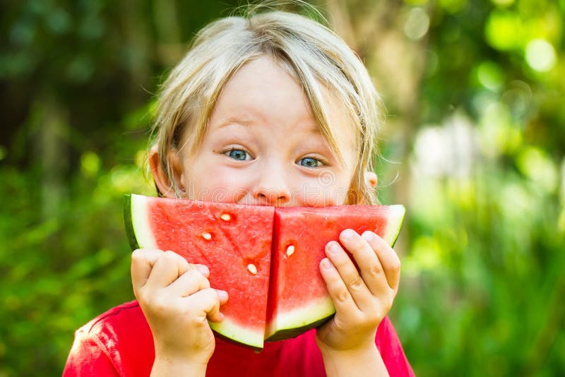 Enfant heureux drôle mangeant la pastèque dehors images stock