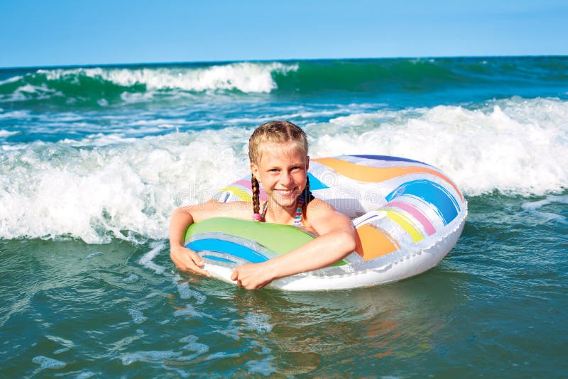 Enfant heureux jouant dans l'eau bleue de l'oc?an sur une station de vacances tropicale ? la mer Bains gais de petite fille dans photographie stock libre de droits Enfant heureux jouant dans l'eau bleue de l'oc?an sur une station de vacances tropicale ? la mer Bains gais de petite fille dans photographie stock libre de droits