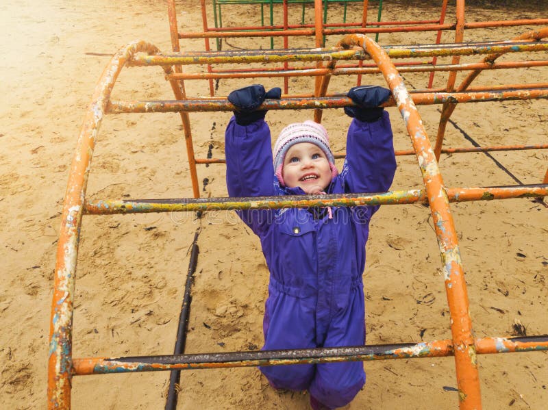 Enfant jouant au terrain de jeu la journée de printemps fraîche photos stock Enfant jouant au terrain de jeu la journée de printemps fraîche photos stock
