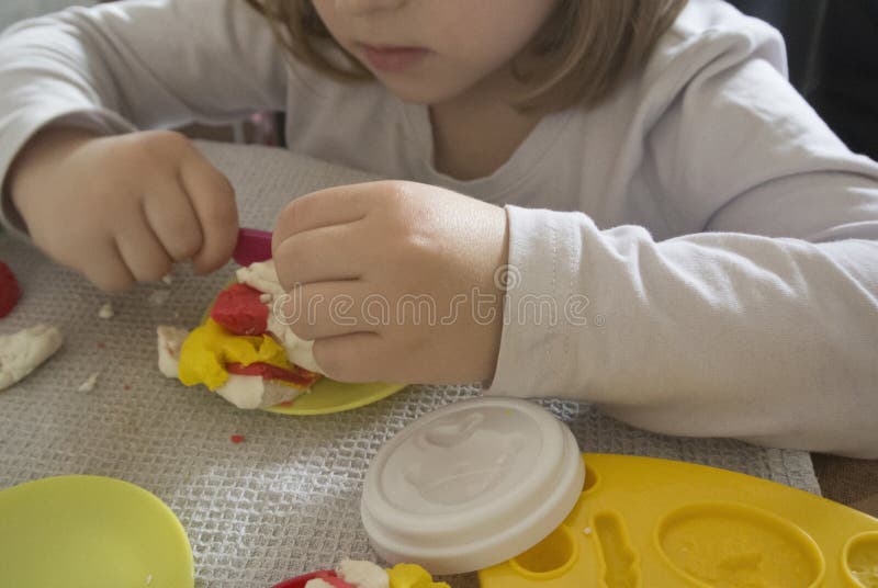 Enfant jouant avec de la pâte à modeler photo stock Enfant jouant avec de la pâte à modeler photo stock