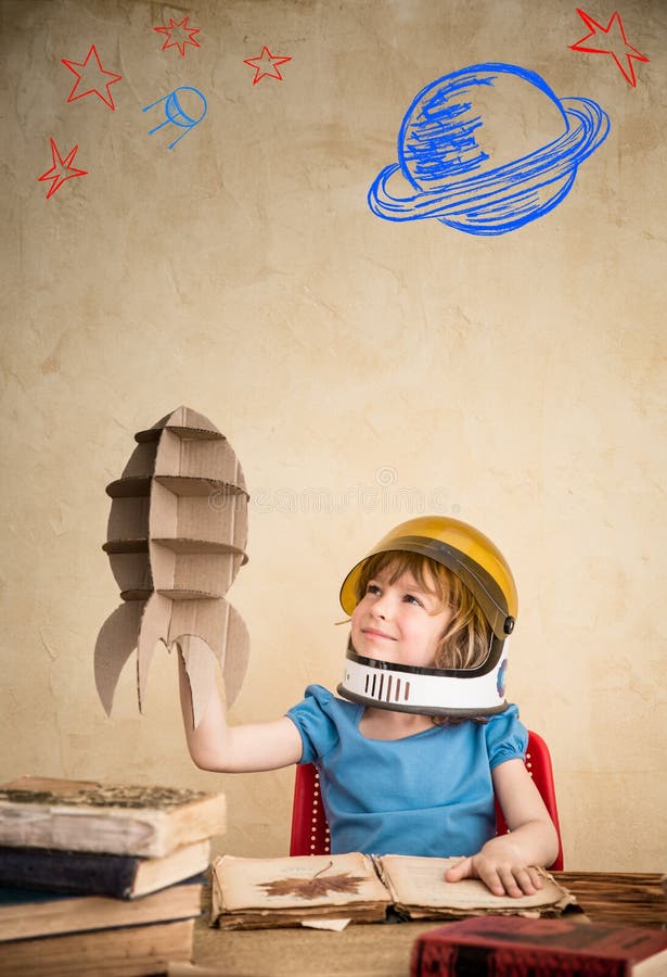 Child astronaut with cardboard toy rocket. Child playing at home. Earth day concept. Child astronaut with cardboard toy rocket. Child playing at home. Earth day concept