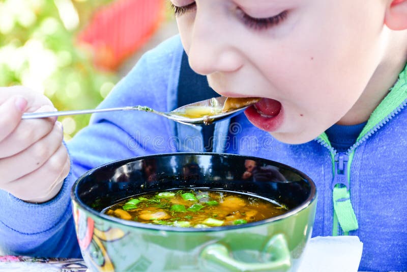 Enfant mangeant d'une soupe images stock Enfant mangeant d'une soupe images stock