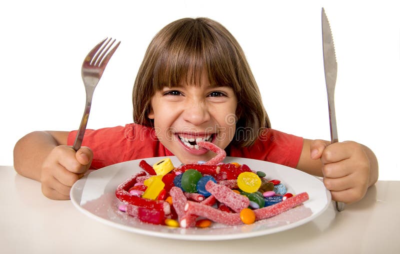 Enfant mangeant la sucrerie comme fou dans l'abus de sucre et le concept doux malsain de nutrition photos libres de droits
