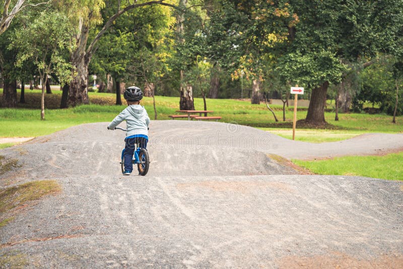 Enfant montant un vélo d'équilibre image stock Enfant montant un vélo d'équilibre image stock