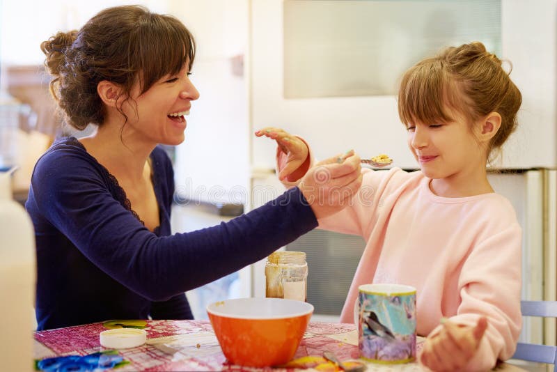Enfant mère heureux et alimentation avec des céréales pour la fibre vitamine ou petit-déjeuner dans la cuisine ensemble à la maiso photos stock
