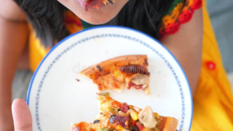 Enfant profiter d'une tranche de pizza veggie jusqu'à fermer pizza topp closeup pizza moment de dégustation banque de vidéos