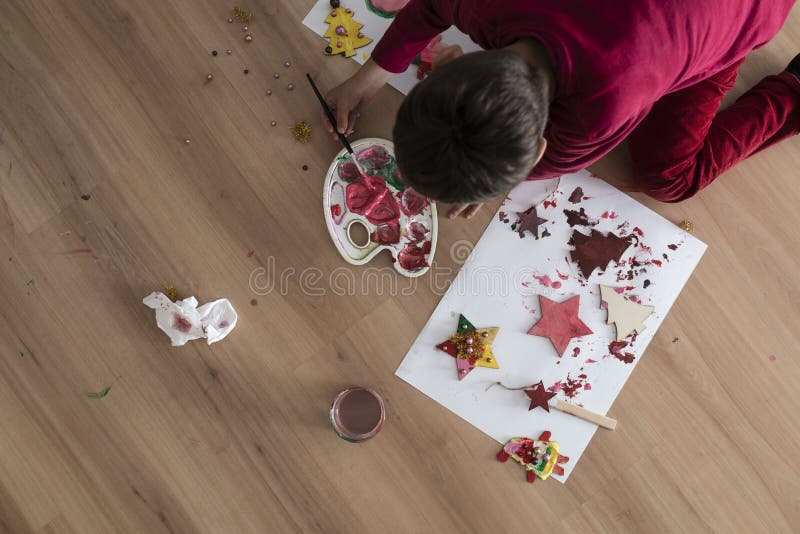 Enfant se mettant à genoux en bas de faire l'artisanat de Noël photos stock