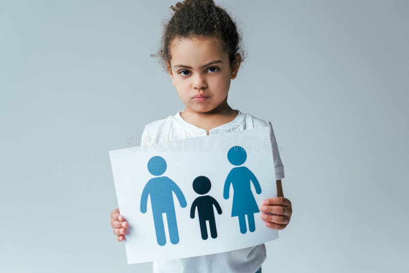 Serious african american kid holding paper with drawn family isolated on grey, adoption concept. Serious african american kid holding paper with drawn family isolated on grey, adoption concept