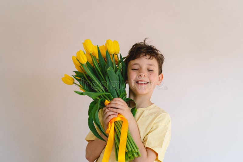 Enfant tenant joyeusement un bouquet de tulipes jaunes vibrantes photographie stock