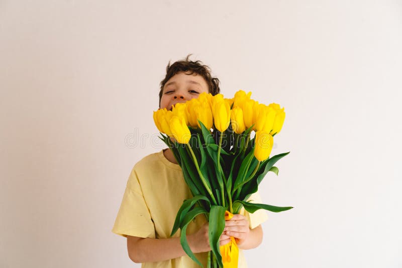 Enfant tenant joyeusement un bouquet de tulipes jaunes vibrantes images libres de droits