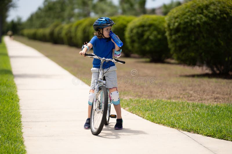 Enfant à vélo. garçon dans un casque à vélo. petit mignon garçon caucasien en sécurité casque équitation vélo dans le parc de la v images libres de droits