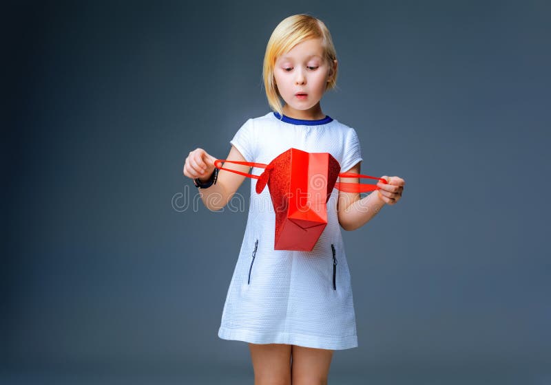 Enfant étonné sur le regard gris dans le panier rouge de Noël photos libres de droits