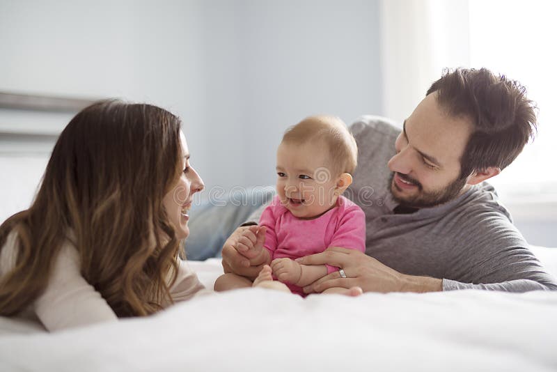Enfantez l'enfant de père et de bébé sur un lit blanc image libre de droits Enfantez l'enfant de père et de bébé sur un lit blanc image libre de droits