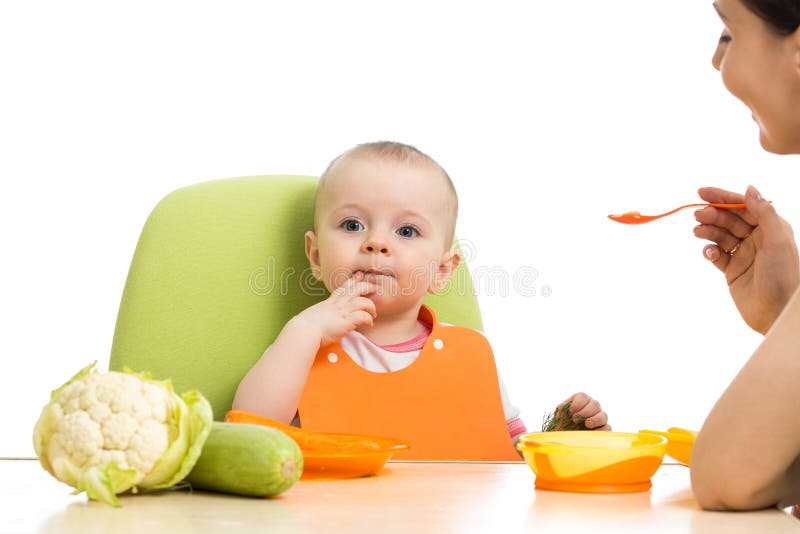Enfantez la cuillère alimentant son bébé d'isolement sur le blanc image stock Enfantez la cuillère alimentant son bébé d'isolement sur le blanc image stock