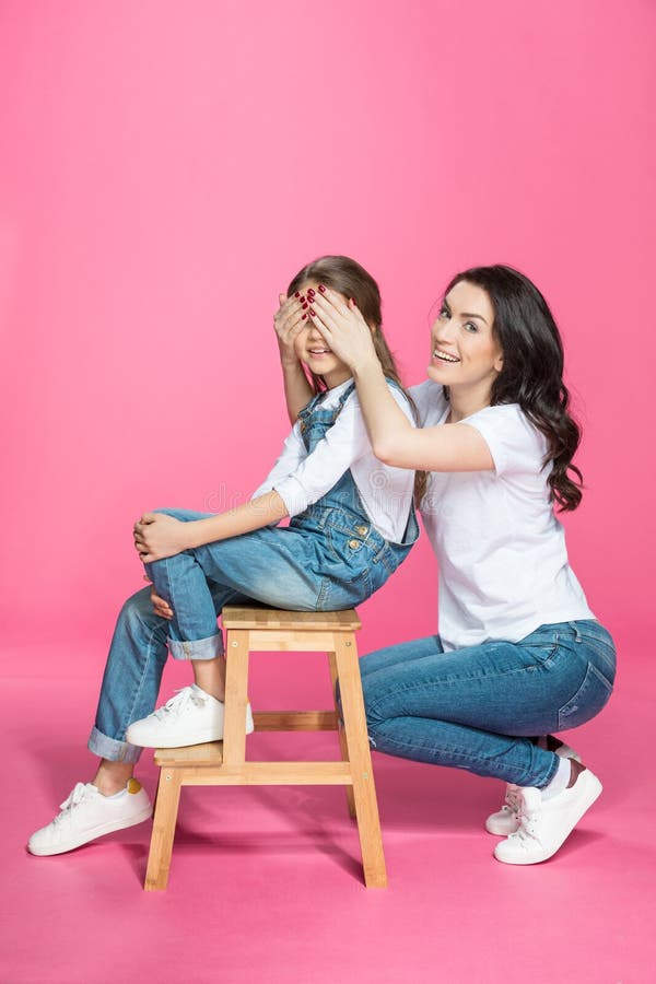 Enfantez les yeux de bâche à la fille de sourire mignonne s'asseyant sur des selles photographie stock Enfantez les yeux de bâche à la fille de sourire mignonne s'asseyant sur des selles photographie stock