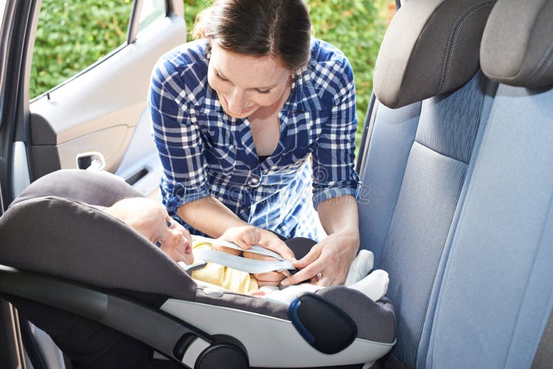 Enfantez mettre le bébé dans la voiture Seat pour le voyage image stock Enfantez mettre le bébé dans la voiture Seat pour le voyage image stock