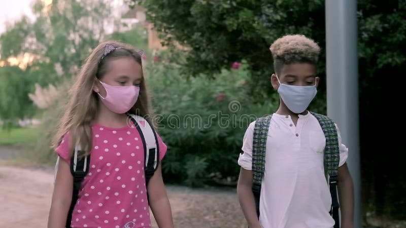 Enfants adorables d'âge scolaire de l'ethniques multiples petits parlant même si à l'école à pied ensemble banque de vidéos