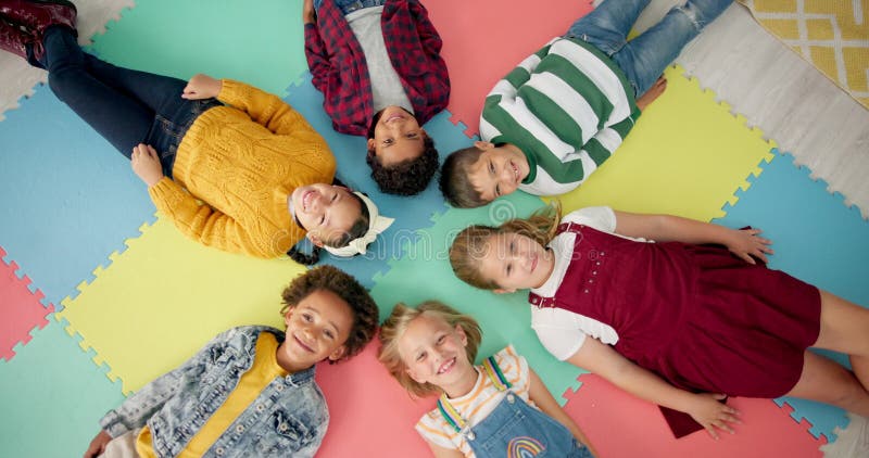 Enfants allongés et rond à l'école avec vue sur le dessus pour se détendre amusant et classe sur matelas en mousse coloré. enfants clips vidéos