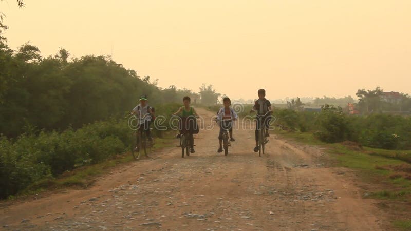 Enfants asiatiques faisant un cycle sur la route