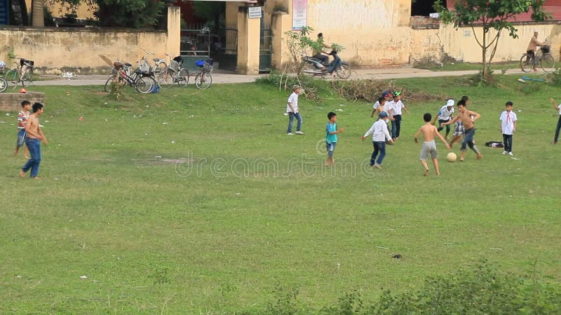 Enfants asiatiques jouant le football