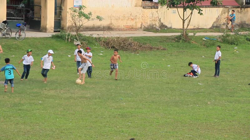 Enfants asiatiques jouant le football