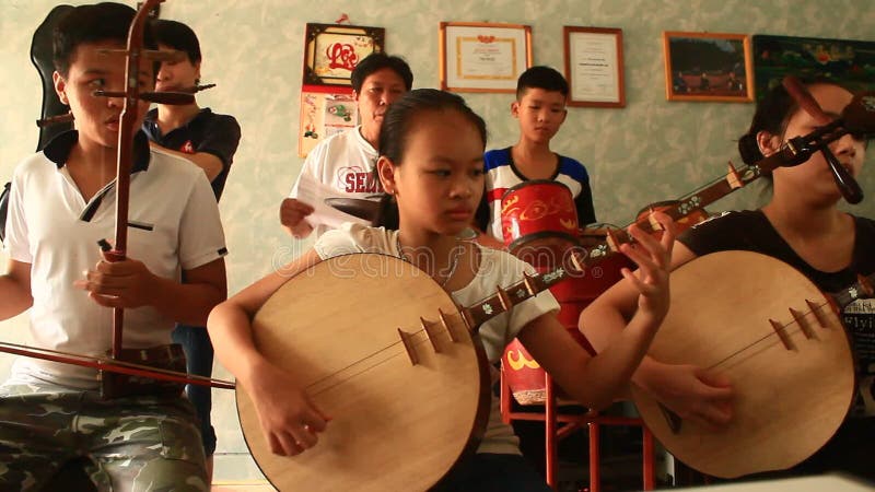 Enfants asiatiques jouant les instruments traditionnels