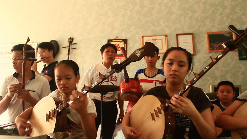 Enfants asiatiques jouant les instruments traditionnels