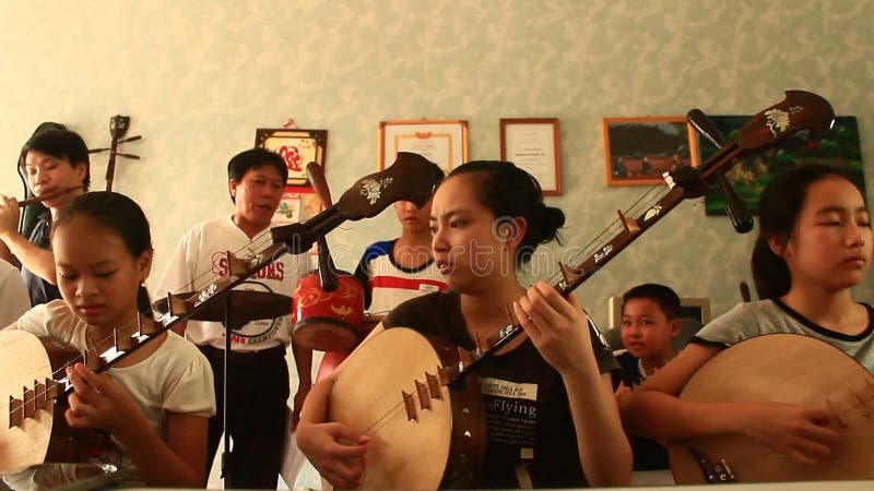 Enfants asiatiques jouant les instruments traditionnels