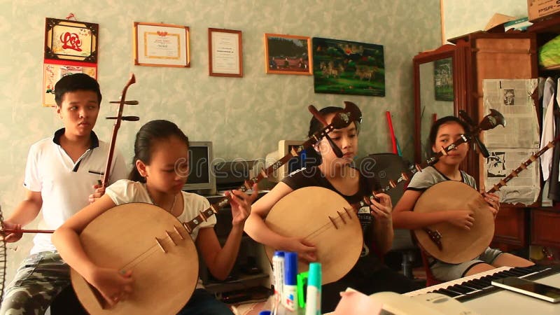 Enfants asiatiques jouant les instruments traditionnels