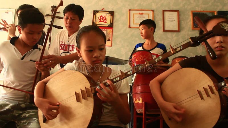 Enfants asiatiques jouant les instruments traditionnels