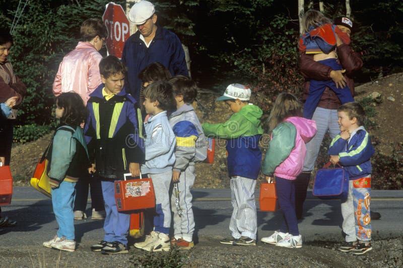 Enfants attendant pour monter à bord de l'autobus scolaire images libres de droits Enfants attendant pour monter à bord de l'autobus scolaire images libres de droits