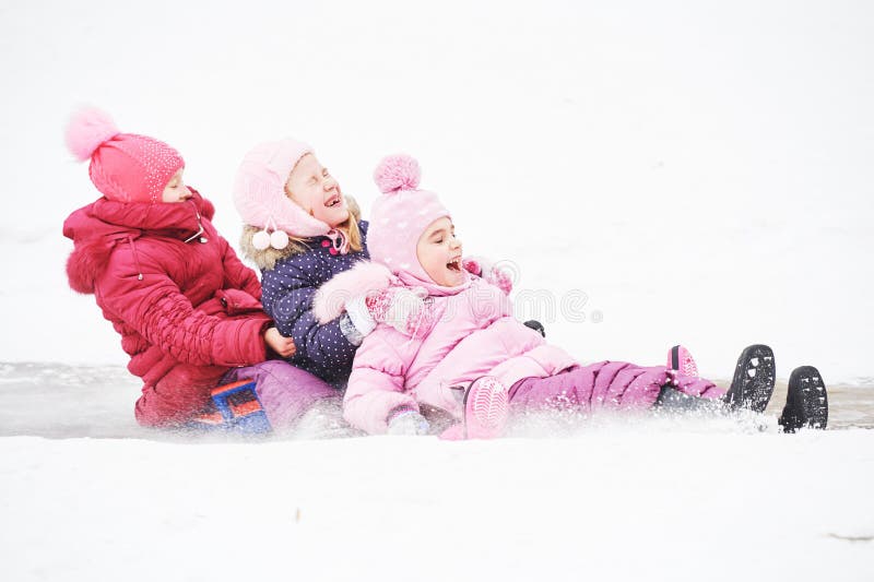 Enfants ayant la glissière de glace d'équitation d'amusement en hiver photos libres de droits Enfants ayant la glissière de glace d'équitation d'amusement en hiver photos libres de droits