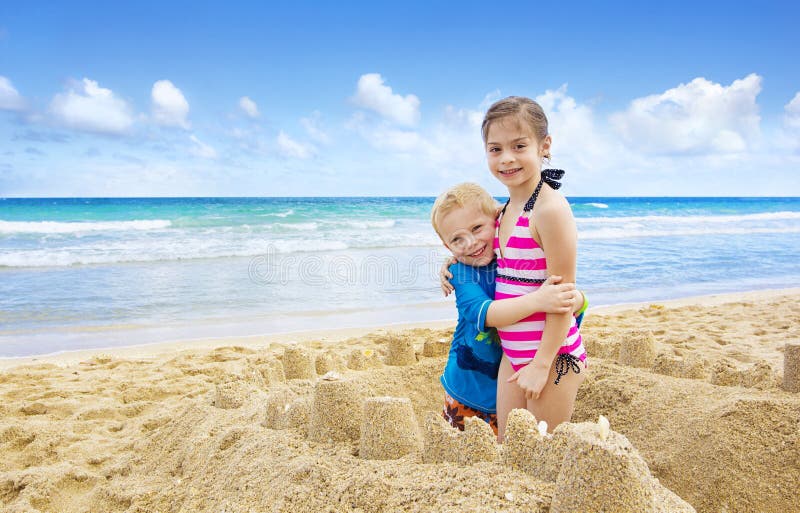 Enfants construisant des pâtés de sable sur la plage image libre de droits Enfants construisant des pâtés de sable sur la plage image libre de droits