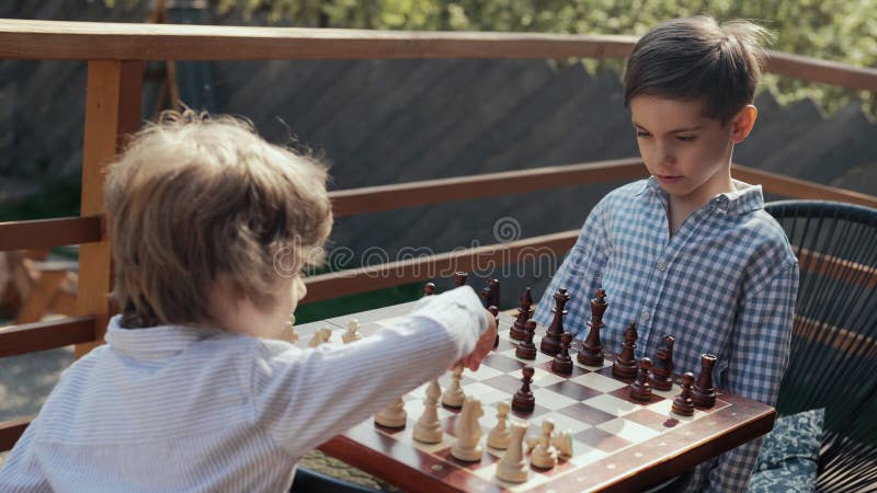 Enfants d'âge préscolaire apprendre jouer à des jeux de société intelligents échecs. Le garçon déplace le morceau de pion clips vidéos