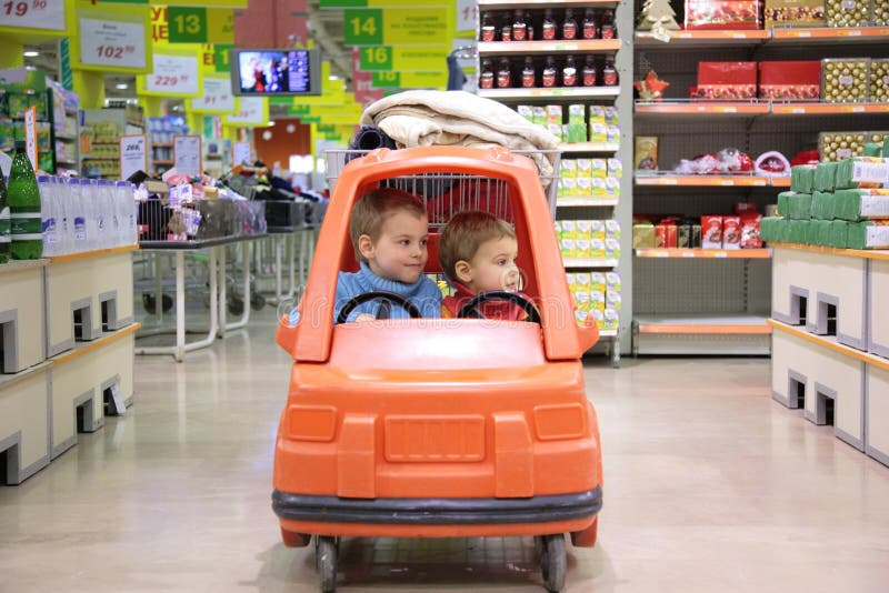 Children in toy automobile in supermarket. Children in toy automobile in supermarket