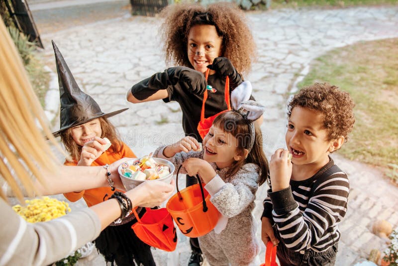 Children in Halloween costumes, trick or treating in front of an old house. Children in Halloween costumes, trick or treating in front of an old house