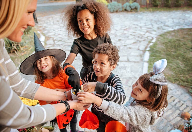 Children in Halloween costumes, trick or treating in front of an old house. Children in Halloween costumes, trick or treating in front of an old house