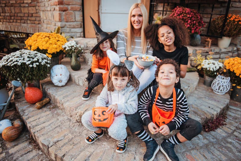 Children in Halloween costumes, trick or treating in front of an old house. Children in Halloween costumes, trick or treating in front of an old house