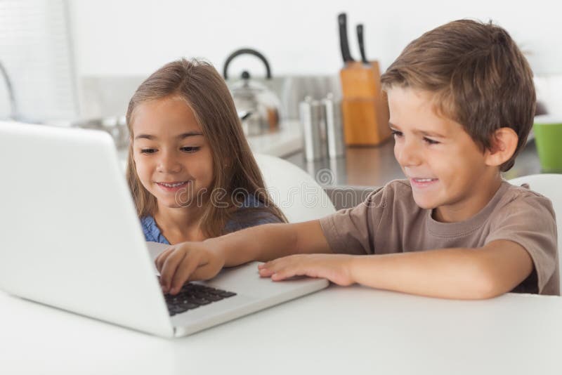 Enfants de mêmes parents à l'aide d'un ordinateur portable ensemble image stock
