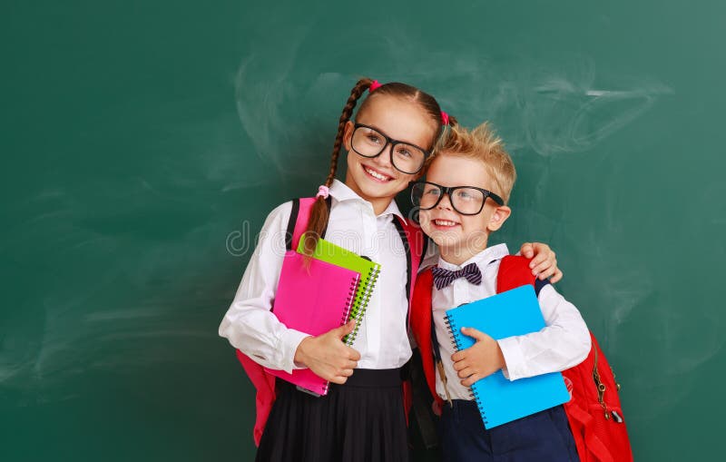 Enfants drôles de groupe écolier et écolière, garçon d'étudiant et fille au sujet de tableau noir d'école images libres de droits Enfants drôles de groupe écolier et écolière, garçon d'étudiant et fille au sujet de tableau noir d'école images libres de droits