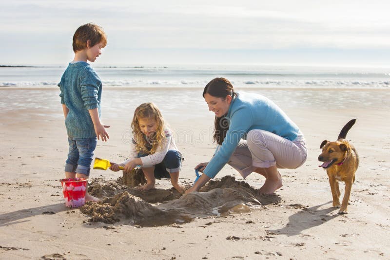 Enfants et chien de mère sur la plage photos libres de droits