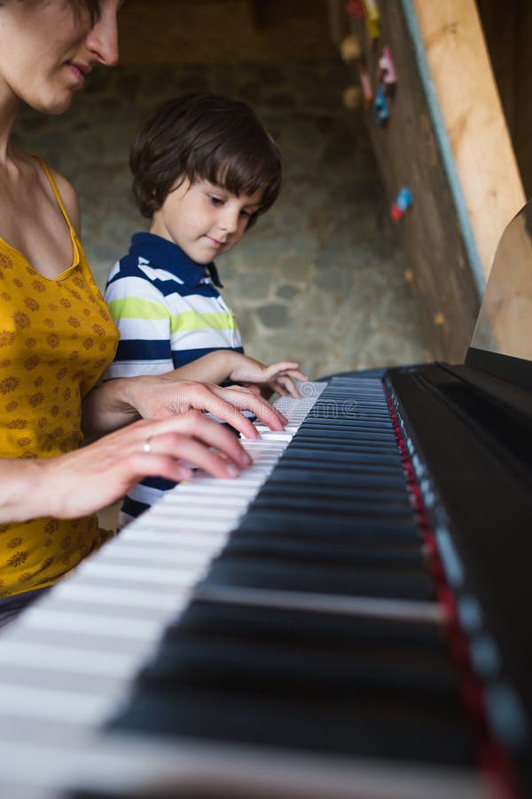 Enfants et mains des femmes sur les clés de piano photographie stock libre de droits Enfants et mains des femmes sur les clés de piano photographie stock libre de droits